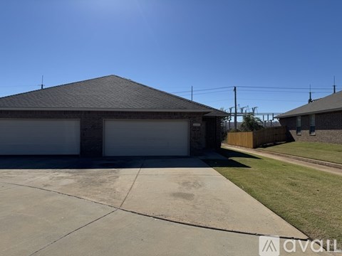 A house with a grey roof and two garages.