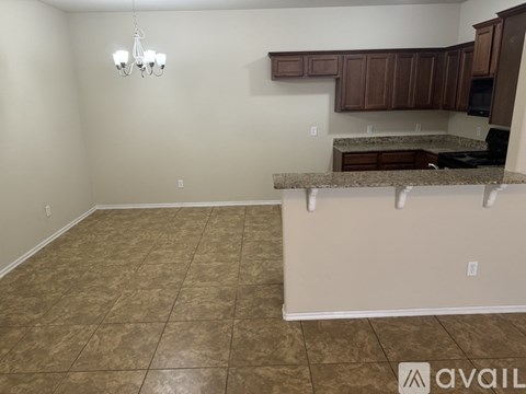 A kitchen area with brown cabinets and a tiled floor.