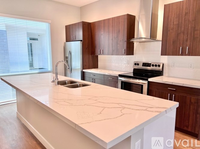 A kitchen with a white countertop and wooden cabinets.