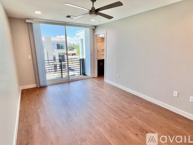 A room with a ceiling fan and sliding glass doors.