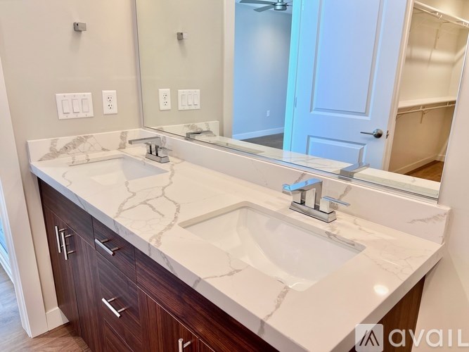 A bathroom with a marble countertop and a large mirror.