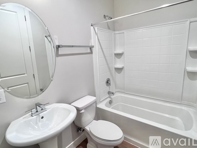A white bathroom with a toilet, sink, and bathtub.