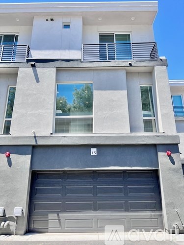A modern two-story building with a garage door labeled 15.