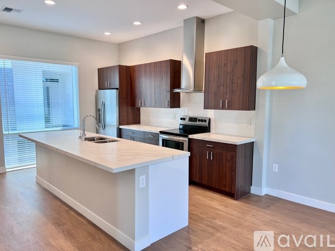 A modern kitchen with wooden cabinets and a white island.