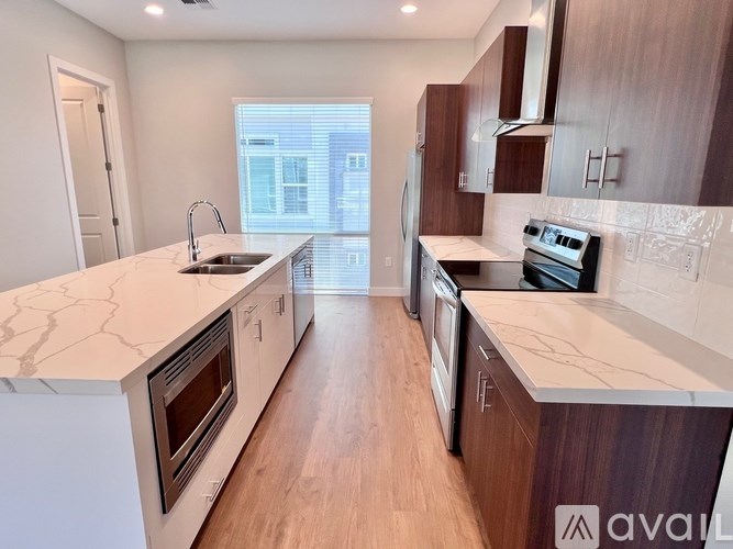 A kitchen with white countertops and wooden cabinets.