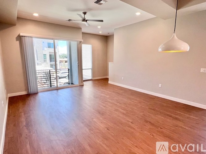 A spacious room with wooden flooring and a ceiling fan.