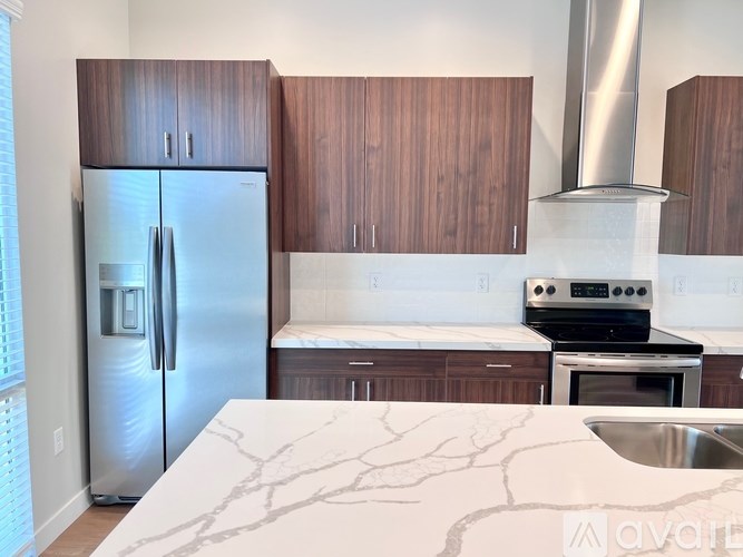 A kitchen with a refrigerator, oven, and sink.