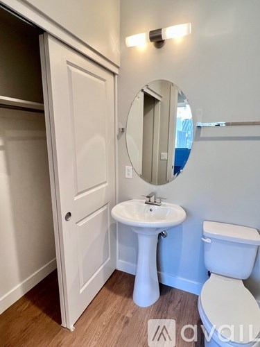 A white bathroom with a sink, toilet and mirror.