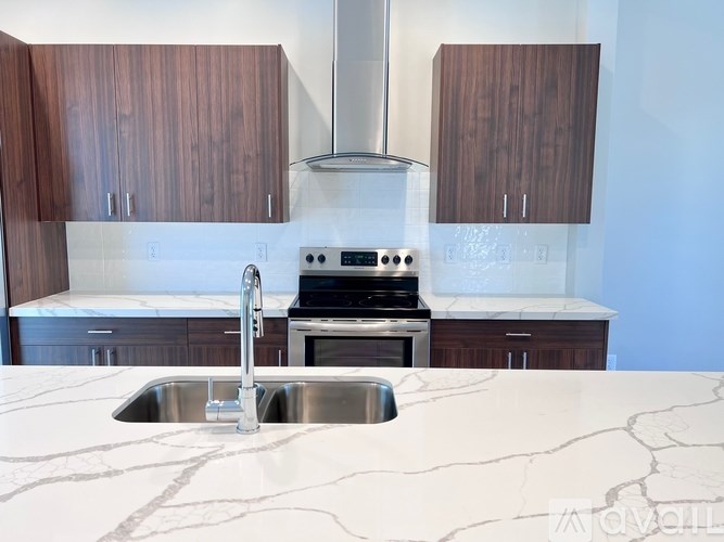 A kitchen with a marble countertop and stainless steel appliances.