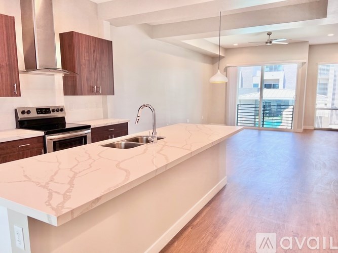 A kitchen with a white countertop and wooden cabinets.