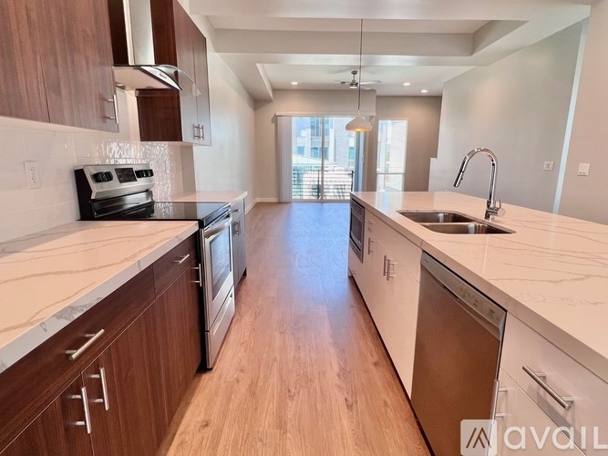A modern kitchen with wooden cabinets and a marble countertop.