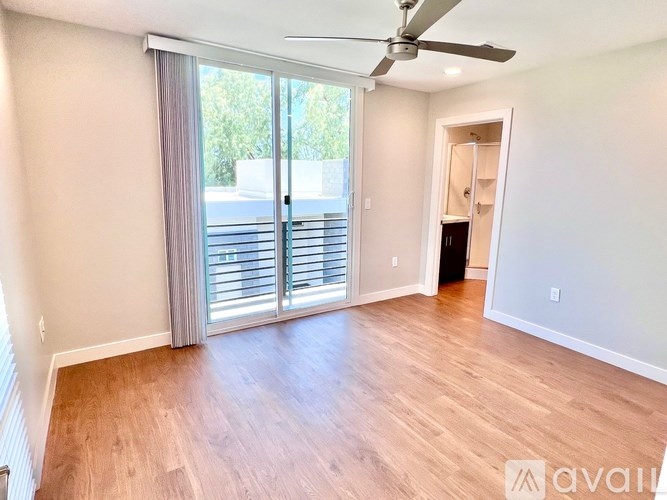A room with a sliding glass door and a ceiling fan.