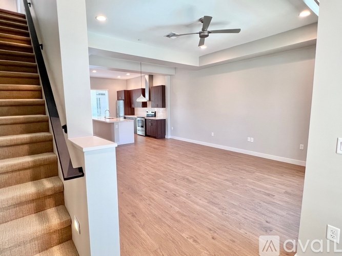A spacious living room with a staircase on the left side.