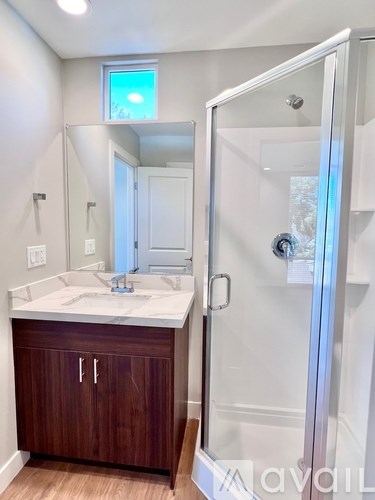 A bathroom with a sink, mirror, and wooden cabinets.