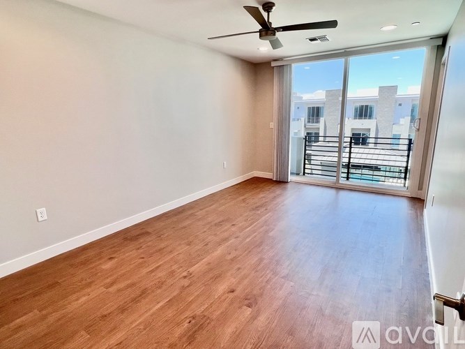 A room with wooden flooring and a ceiling fan.