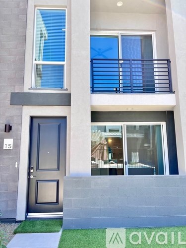 A modern house with a black door and a balcony.