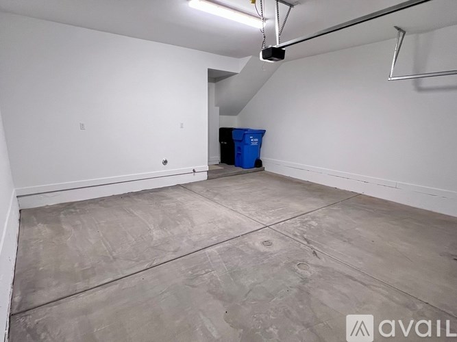 A room with a blue bin and a white wall.