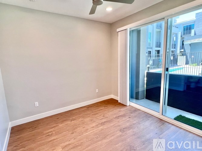 A room with a sliding glass door leading to a balcony.