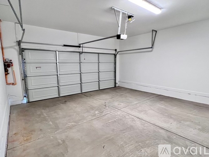A garage with a white wall and a closed white door.
