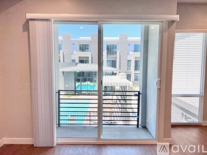 A balcony with a pool and buildings in the background.