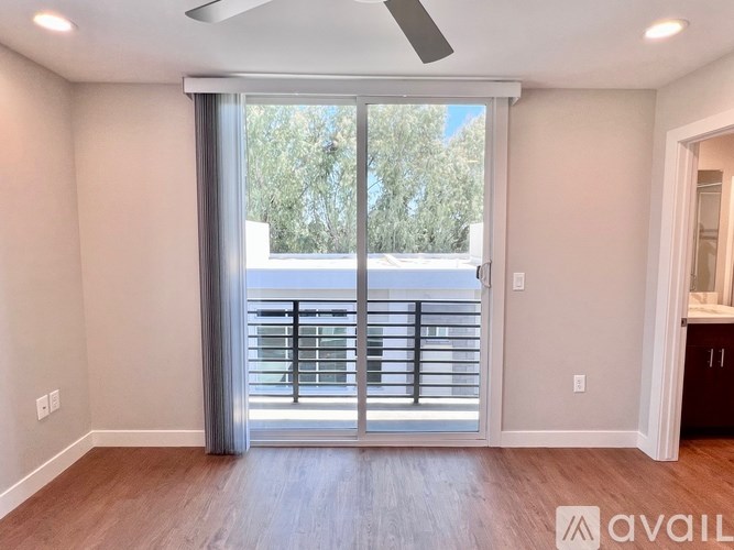 A room with a sliding glass door leading to a balcony.