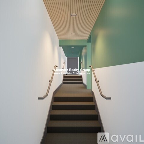A staircase with a landing and a green wall.