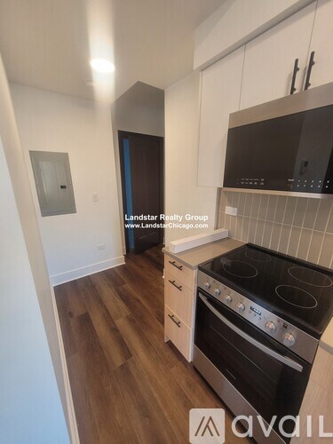 A kitchen with a black stove top oven and white cabinets.