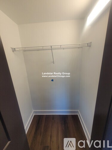 A small, empty room with a wooden floor and a white wall.