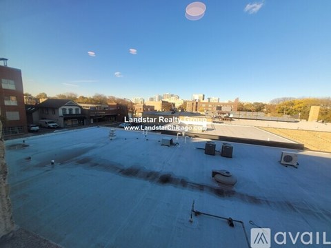 A rooftop with a clear sky and some clouds in the distance.