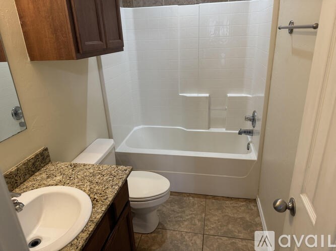 A bathroom with a toilet, sink, and bathtub.