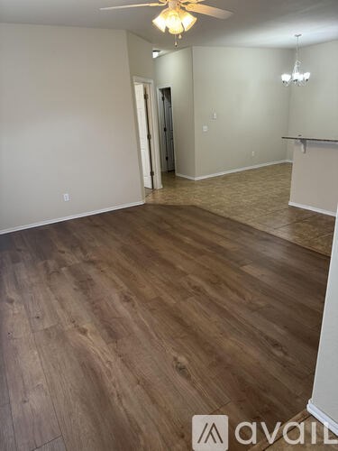 A room with wooden flooring and a ceiling fan.