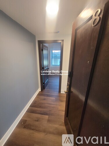 A hallway with a door on the right and a sign that says "Landstar Realty Group" on the wall.