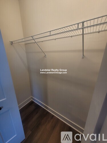 A white closet with a metal rack and a door.
