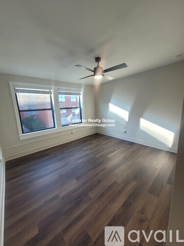 A room with wooden flooring and a ceiling fan.