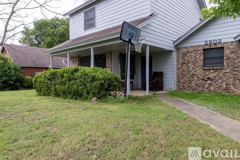 A house with a basketball hoop in the front yard.