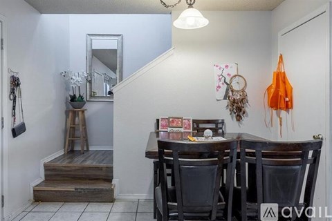A dining room with a wooden table and chairs.