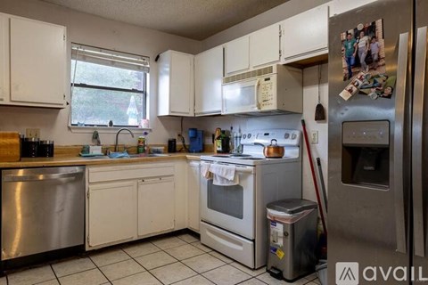 A kitchen with white cabinets and a stainless steel dishwasher.