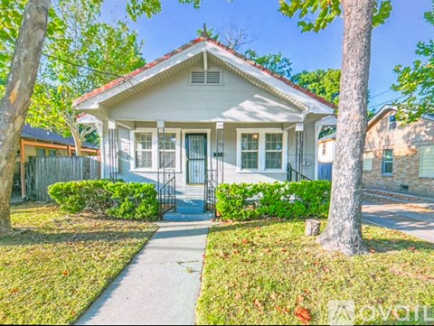 A white house with a red roof and a small front porch.