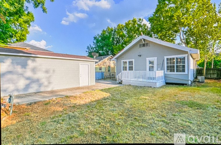 A house with a white garage door is surrounded by trees.