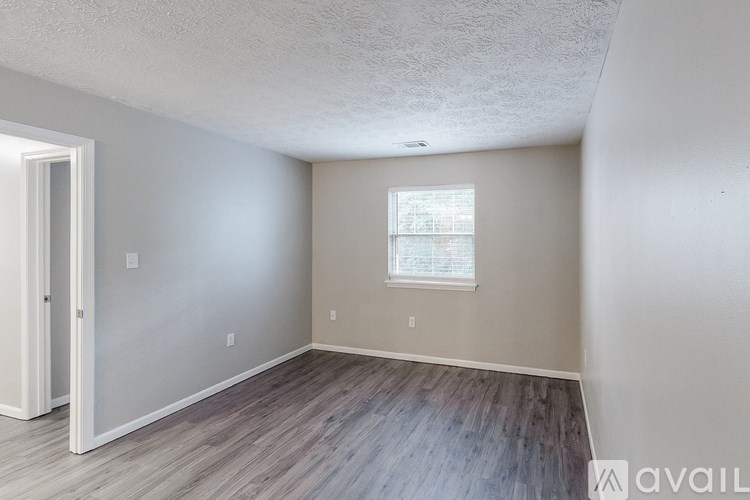 A room with a window and wooden flooring.