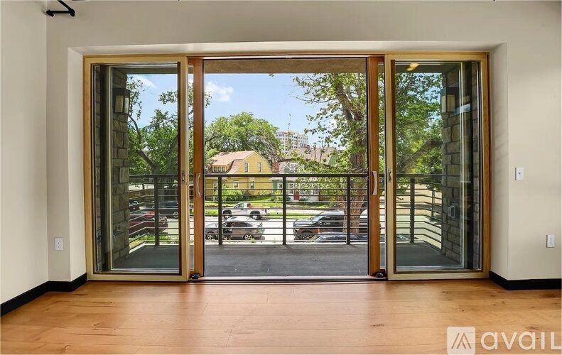 A room with a view of a parking lot through a glass door.