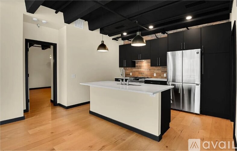 A kitchen with black cabinets and a white island.