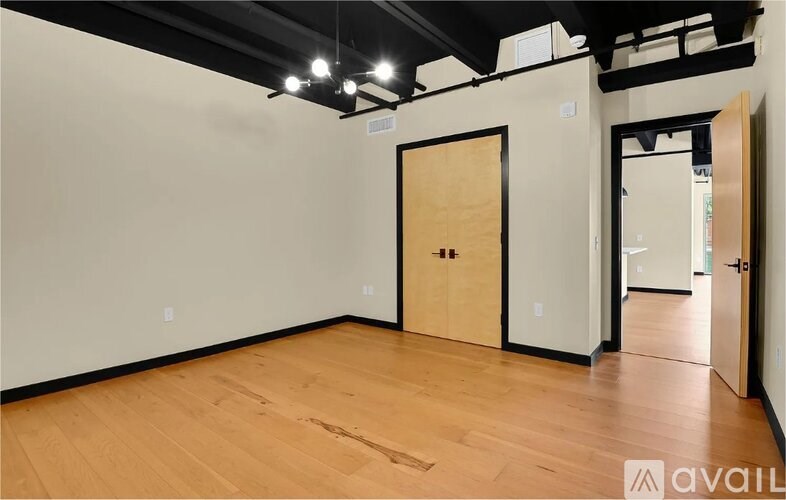 A room with wooden floors and a door in the middle.