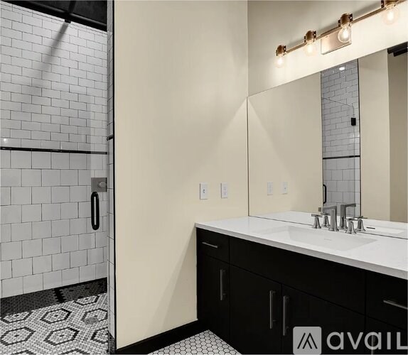 A bathroom with a white sink and black cabinets.