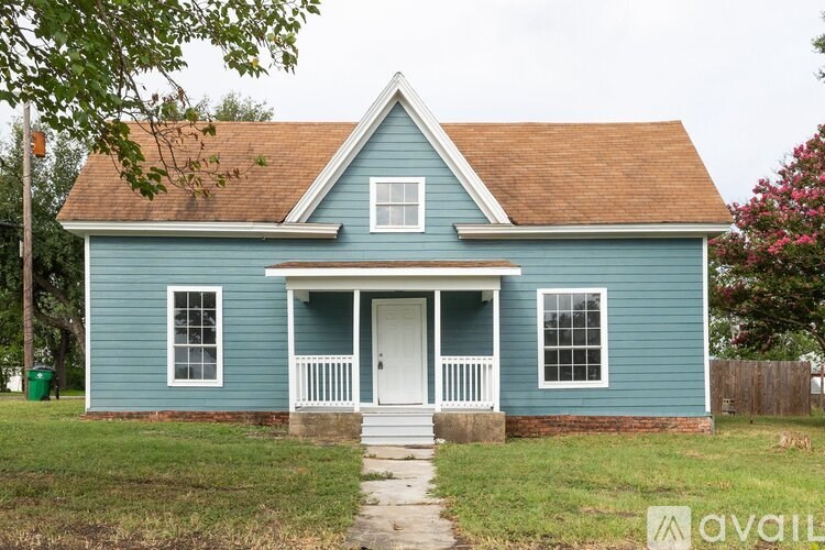 A blue house with a white door and windows.