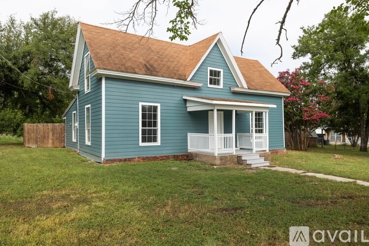 A blue house with a brown roof and white trim.