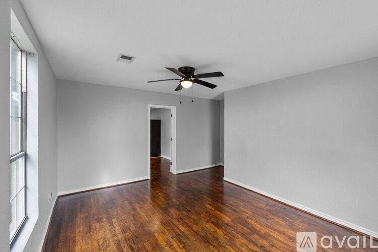 A room with wooden floors and a ceiling fan.