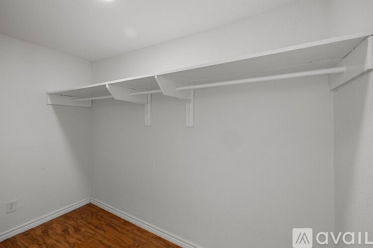 Empty room with white walls and wooden floor.