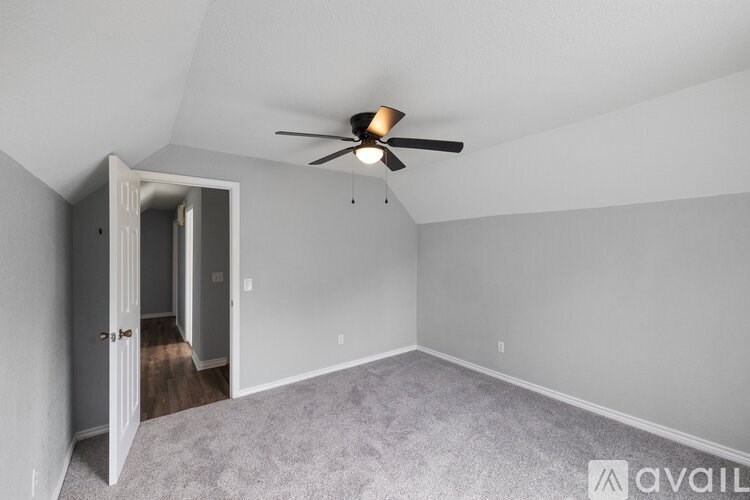 A room with a ceiling fan and carpeted floor.
