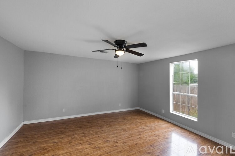 A room with a ceiling fan and wooden flooring.